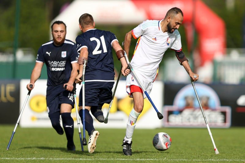 Twee spelers op krukken vechten om de bal langs de zijlijn