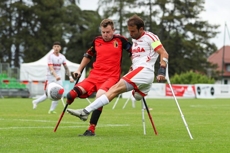 Speler in het rode shirt van België trapt de bal weg tijdens het EK