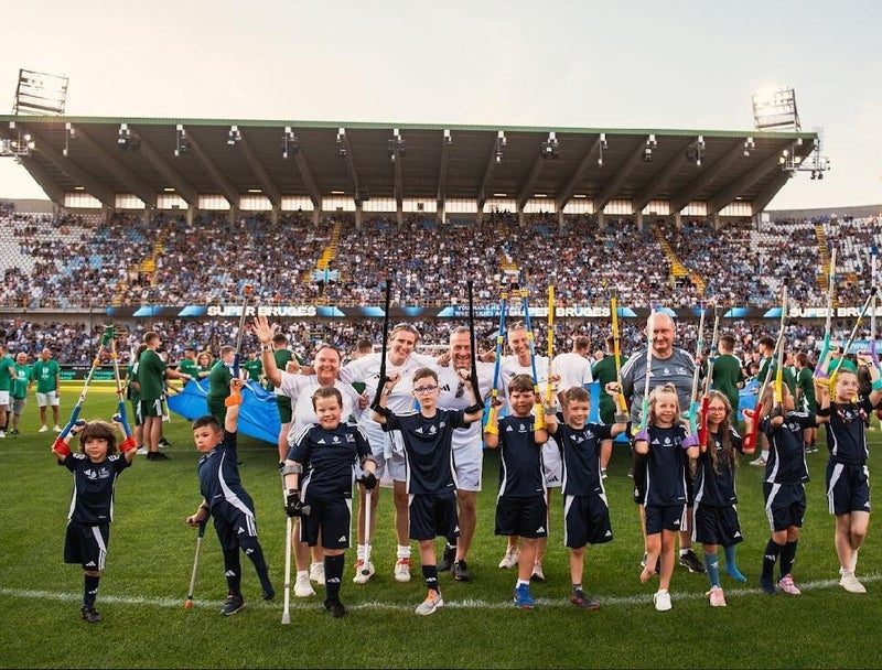Jonge spelers zwaaien naar het publiek in een vol stadion